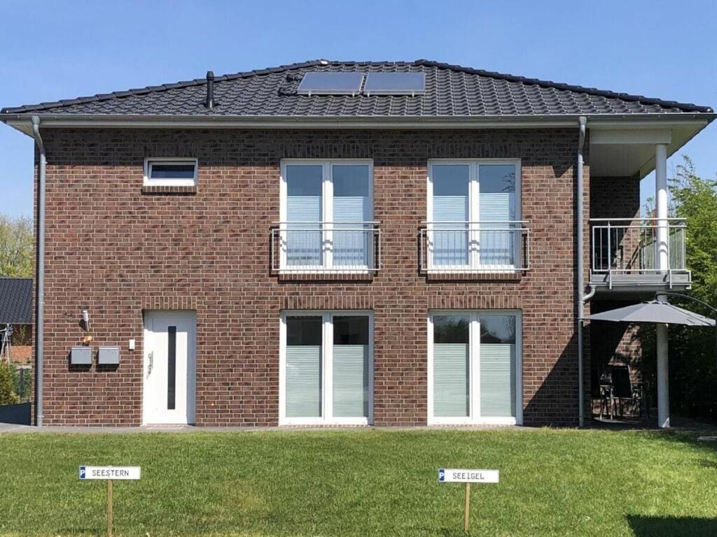 a red brick house with windows and a balcony at Holiday apartment starfish in Butjadingen