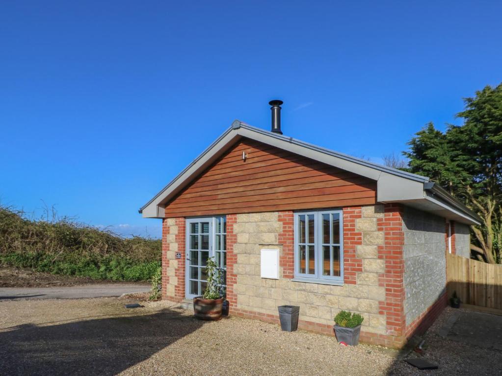 a small brick house with a window on a street at The Pepper Pot Retreat in Ventnor