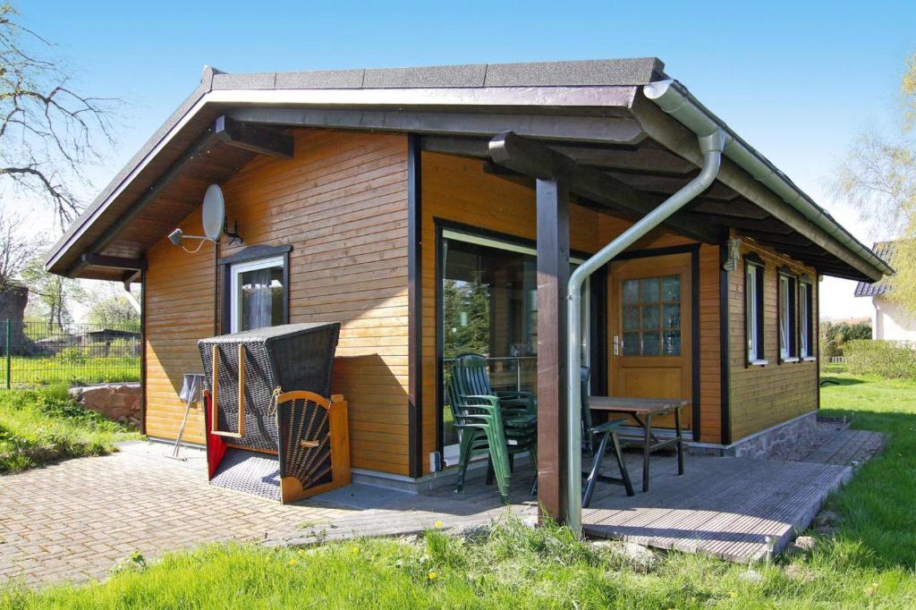 a small wooden cabin with a table and chairs at Holiday home lake view Zemitz in Zemitz