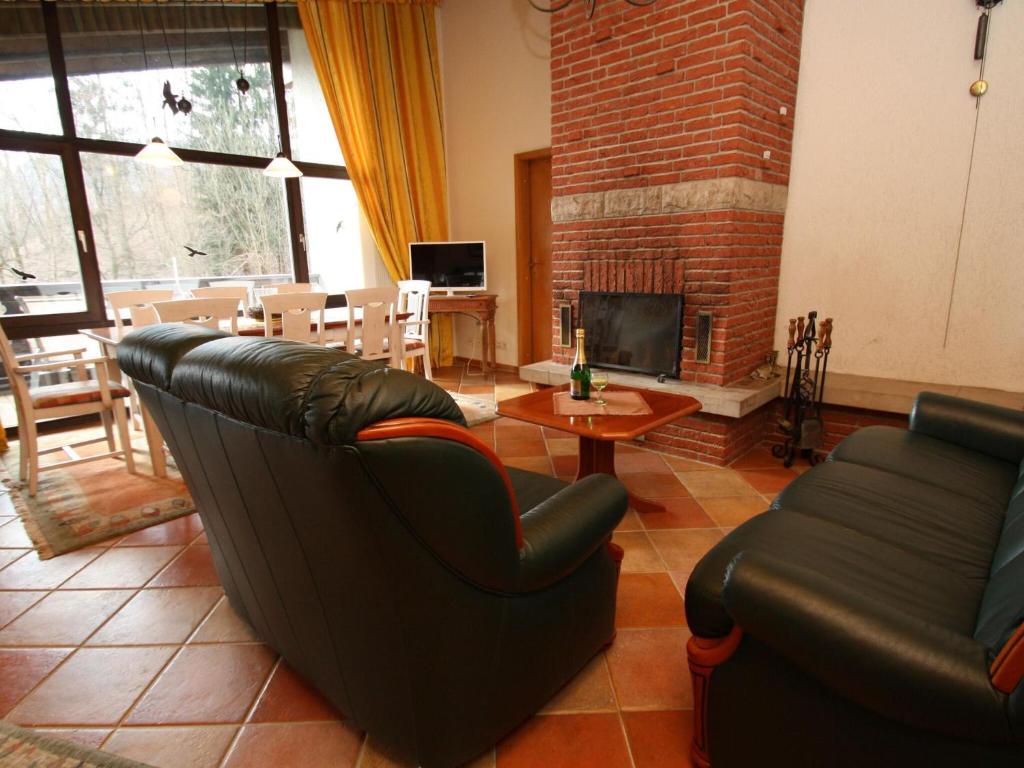 ein Wohnzimmer mit einem Sofa und einem Kamin in der Unterkunft Apartment house Schiefertal, Wieda in Wieda