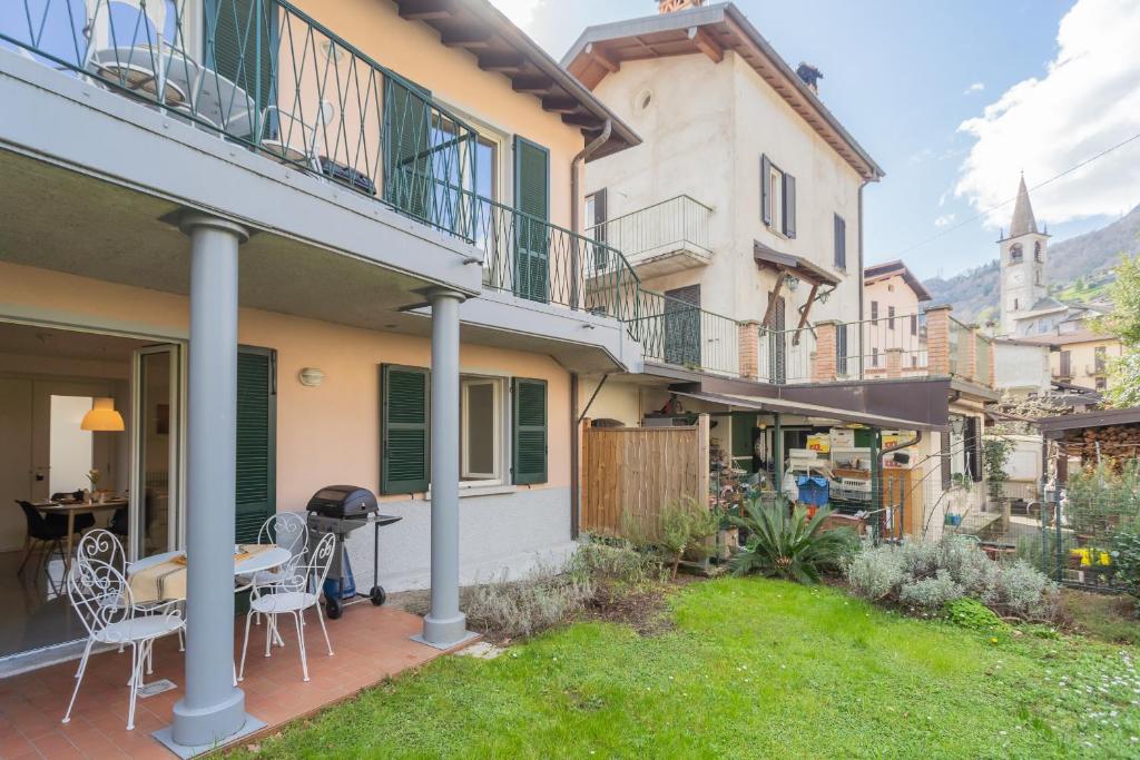 a patio with a table and chairs in a yard at Ponente Balcony & Garden by Rent All Como in Gravedona