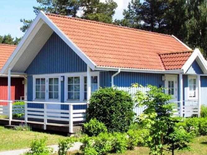 a small blue house with an orange roof at Ferienhaus am Useriner See, Userin in Userin