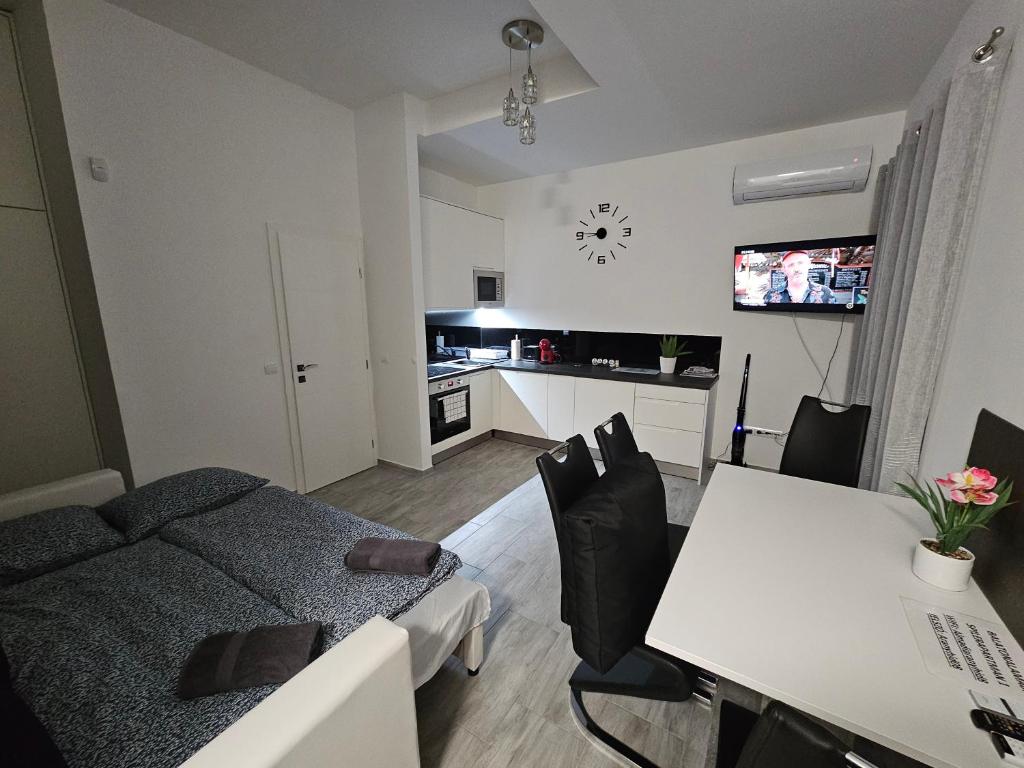 ein Wohnzimmer mit einem Sofa und einem Tisch mit Stühlen in der Unterkunft Spílerapartman 1 in Balatonalmádi
