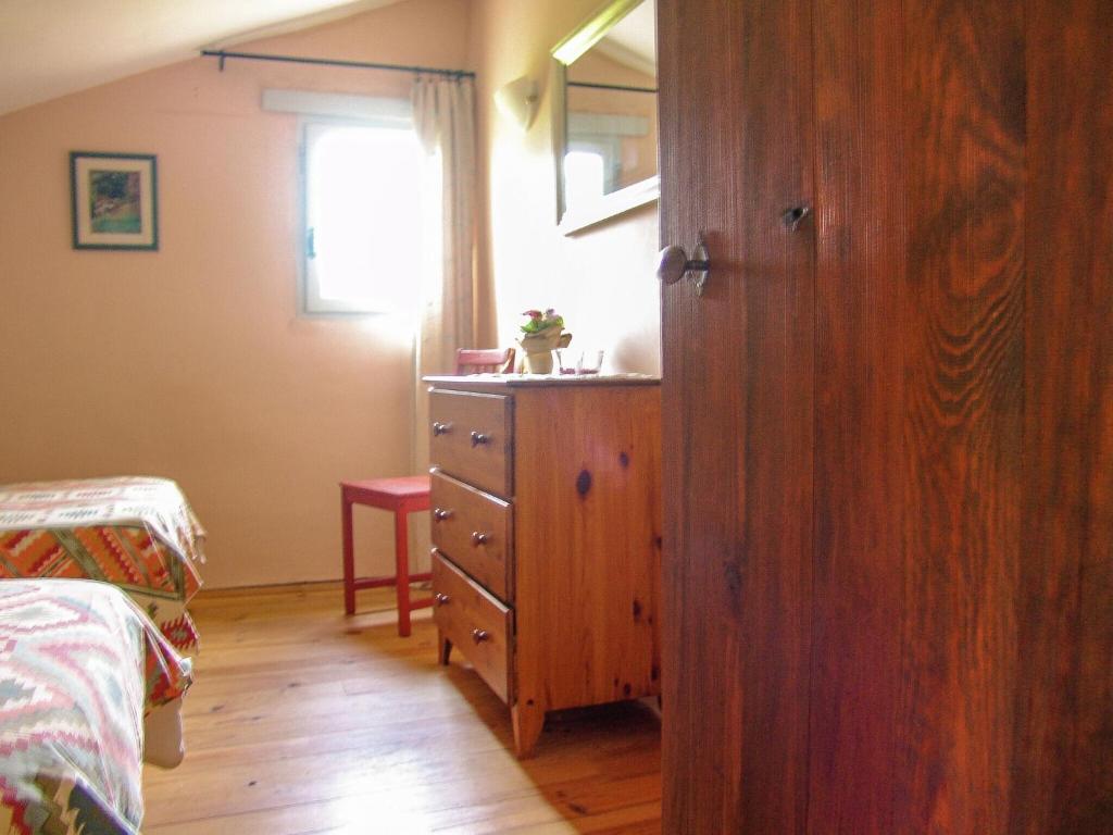 a bedroom with a wooden dresser and a window at Snug cottage in Saint Eutrope De Born with pool in Saint-Eutrope-de-Born