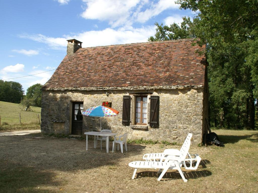 Saint-Germain-de-BelvèsにあるQuaint Home in Berbigui res Valley of the Castles at 15minの石造りの家(テーブル、椅子、傘付)