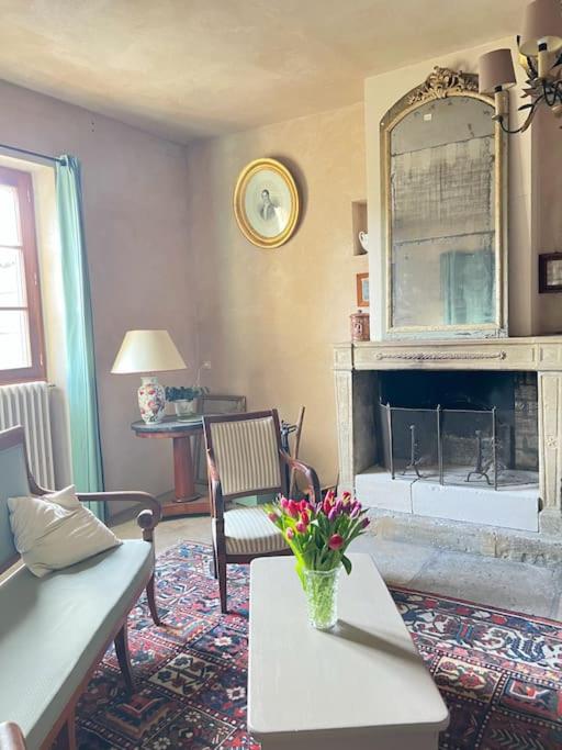 - un salon avec une cheminée et une table fleurie dans l'établissement Mas Les Bartavelles - Drôme, à Réauville