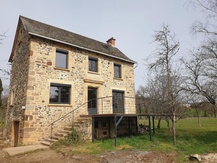 une vieille maison en pierre avec un escalier dans un champ dans l'établissement Gîte des bords du Lot, à Saint-Côme-dʼOlt