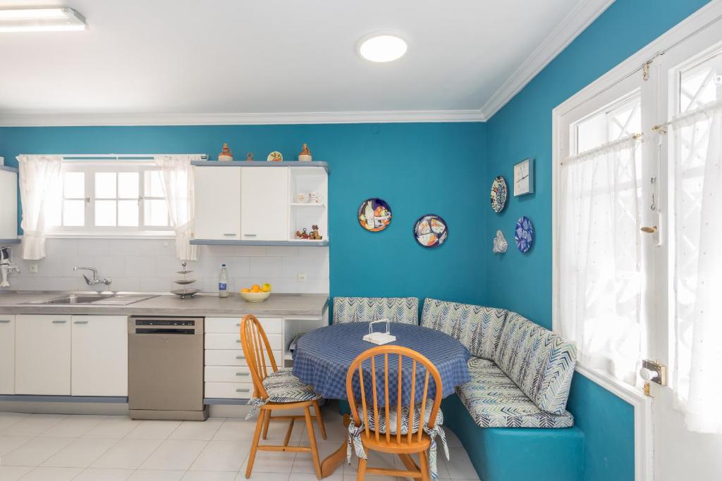 eine Küche mit blauen Wänden sowie einem Tisch und Stühlen in der Unterkunft Bandama Country Home - 3BR with garden in Santa Brígida
