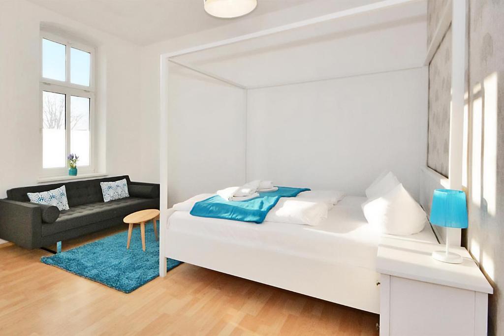 アールベックにあるApartment Karlskronaの白いベッドルーム(ベッド1台、ソファ付)
