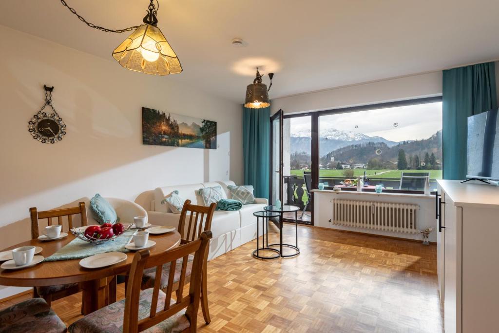 a dining room and living room with a table and chairs at Ferienwohnung Kaiserpanorama - Alpenmagie Suites in Oberaudorf
