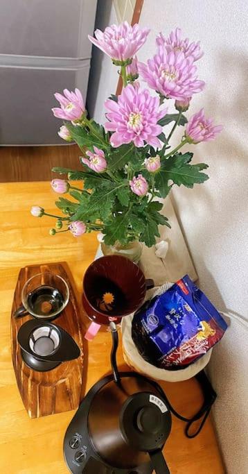 a table with a vase with pink flowers in it at Pokémon Sleep 宝可梦的家 in Osaka