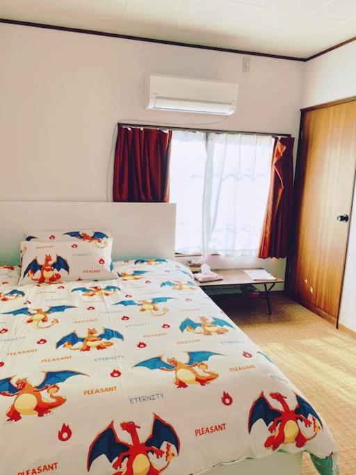a bedroom with a large bed with a pokemon comforter at Pokémon Sleep 宝可梦的家 in Osaka