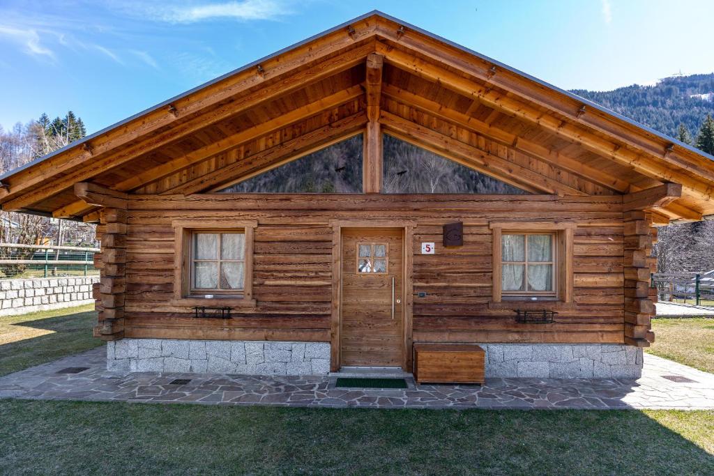a log cabin with a large roof at Chalet Camping Faè 5 - Trilocale in Madonna di Campiglio