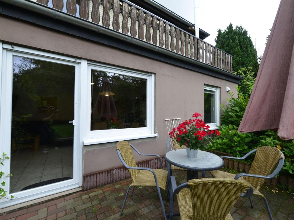 patio con mesa, sillas y ventana en Garden view Apartment in Heringhausen Lake City Centre en Heringhausen