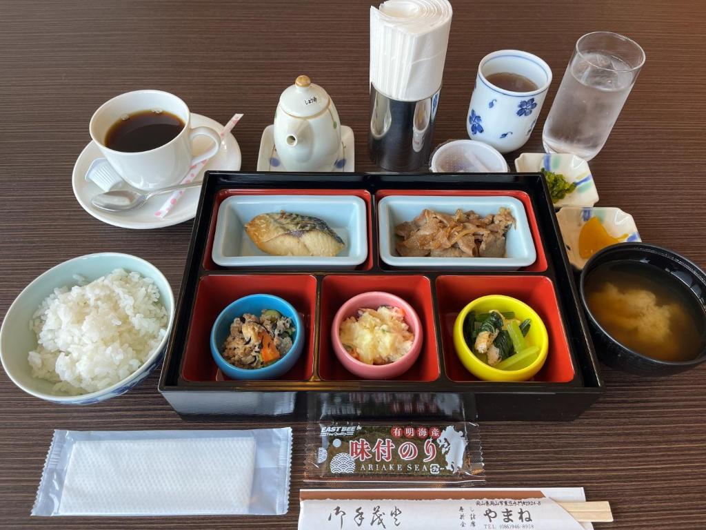 een dienblad met eten op een tafel met een kopje koffie bij SAIDAIJI GRAND HOTEL - Vacation STAY 92825 in Okayama