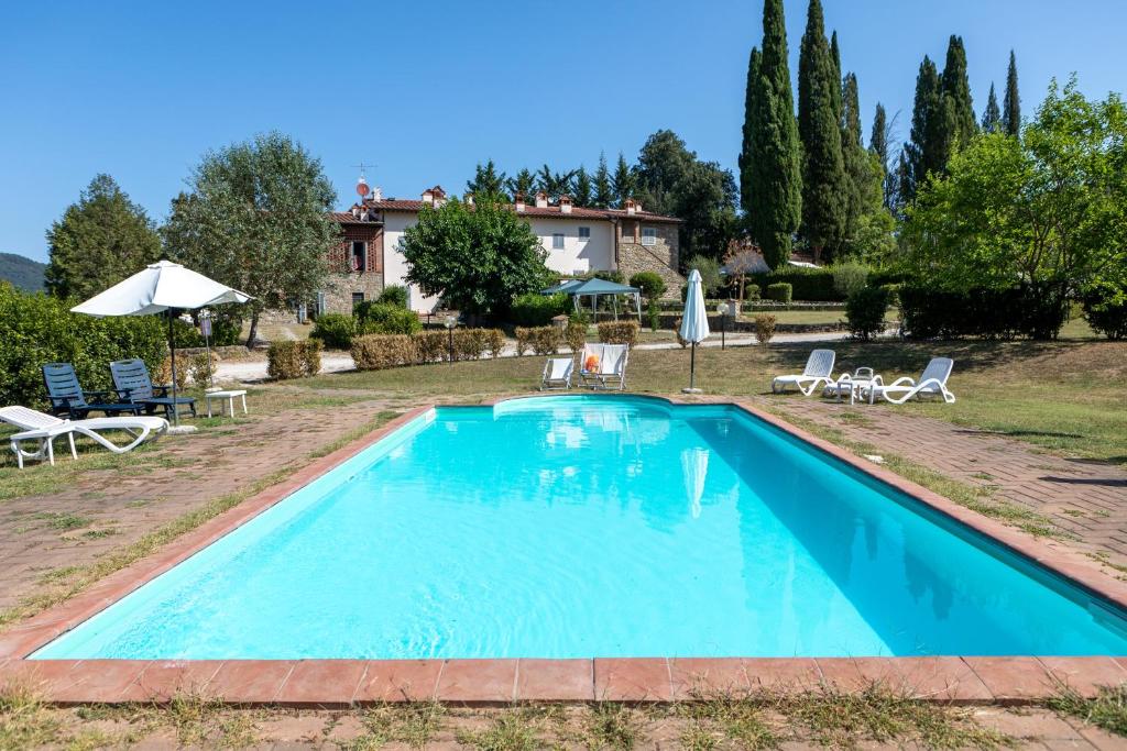 uma piscina em frente a uma villa em Casa le Capanne em Greve in Chianti