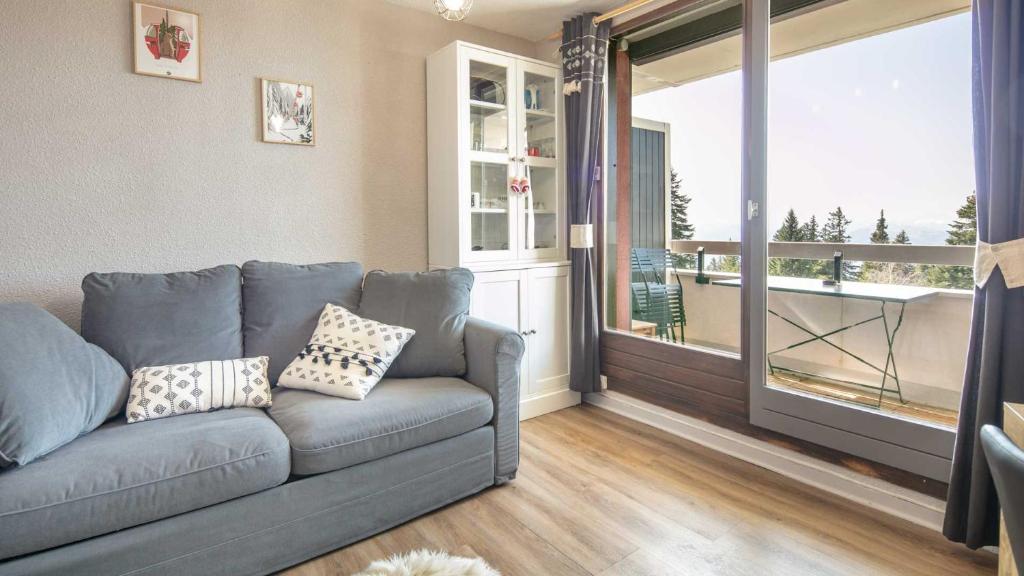a living room with a couch and a large window at Les Marmottes -311- appt lumineux 4-6 pers in Chamrousse