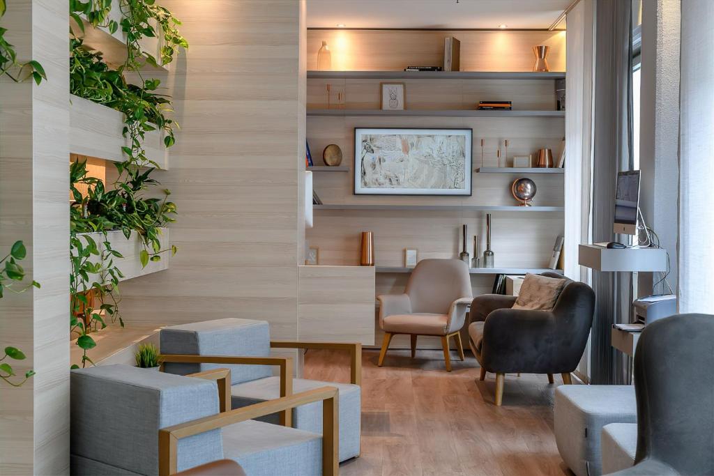 a waiting room with chairs and a table and a desk at Novotel Frankfurt City in Frankfurt