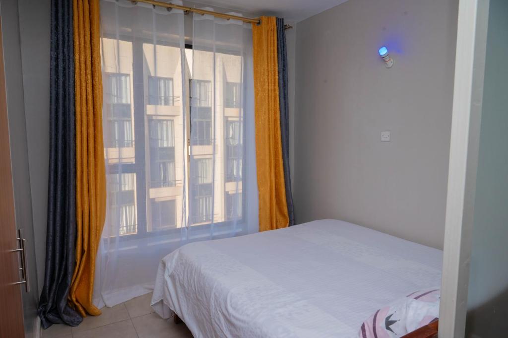 een slaapkamer met een bed en een raam bij Hassan Furnished Superior Studio, Nairobi in Nairobi