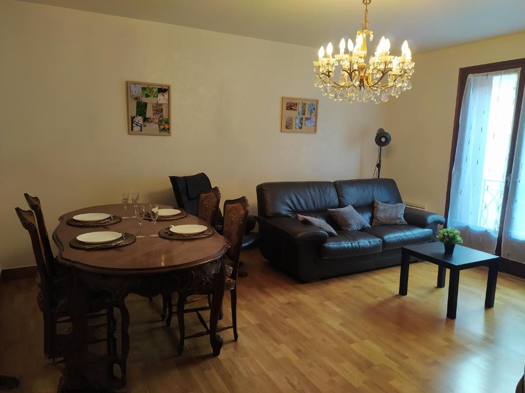 a living room with a table and a leather couch at Gîte l' Odyssée in Espalion