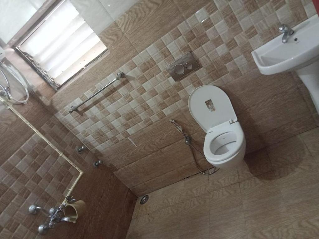 a bathroom with a toilet and a sink at Royal Queen Residency in Ooty