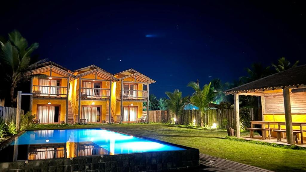 a house with a swimming pool at night at Bibis house in Porto Seguro