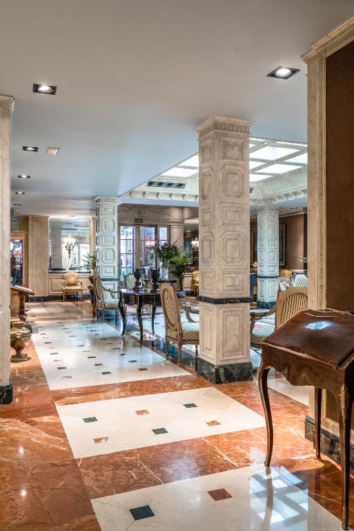 Relais & Châteaux Hotel Orfila في مدريد: لوبي مع طاولة وكراسي وبيانو