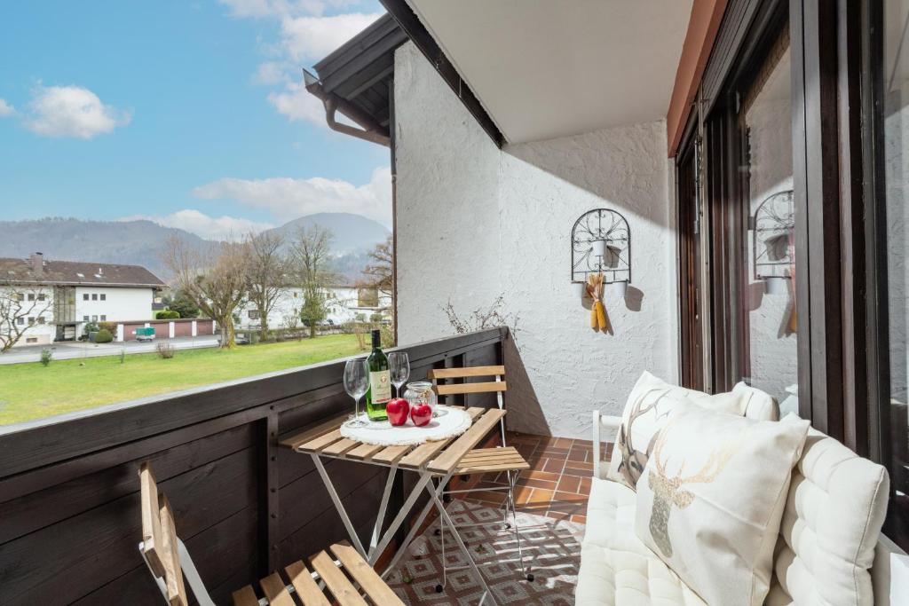 a patio with a table and chairs on a balcony at Ferienwohnung Kranzhornblick - Alpenmagie Suites in Oberaudorf