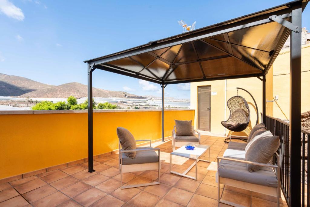 einen Pavillon auf einem Balkon mit Stühlen und einem Tisch in der Unterkunft Las Fajanas de Gáldar in Las Palmas de Gran Canaria