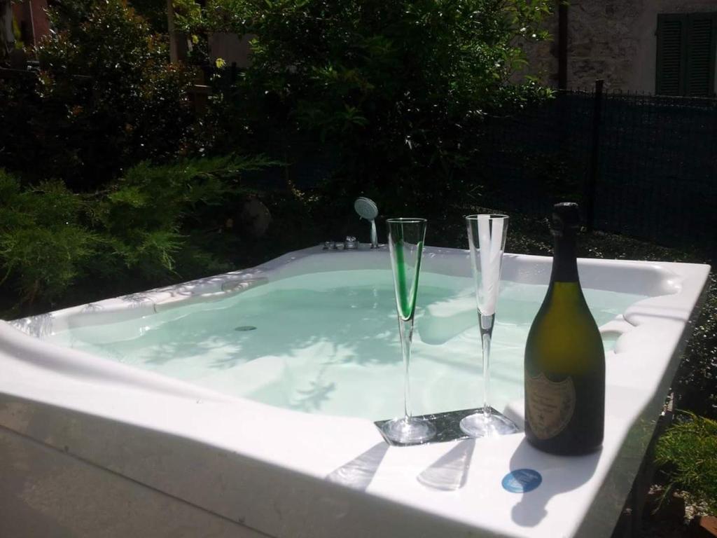 a bottle of champagne and two glasses in a tub at Lovely House with Two Jacuzzi in Veleso