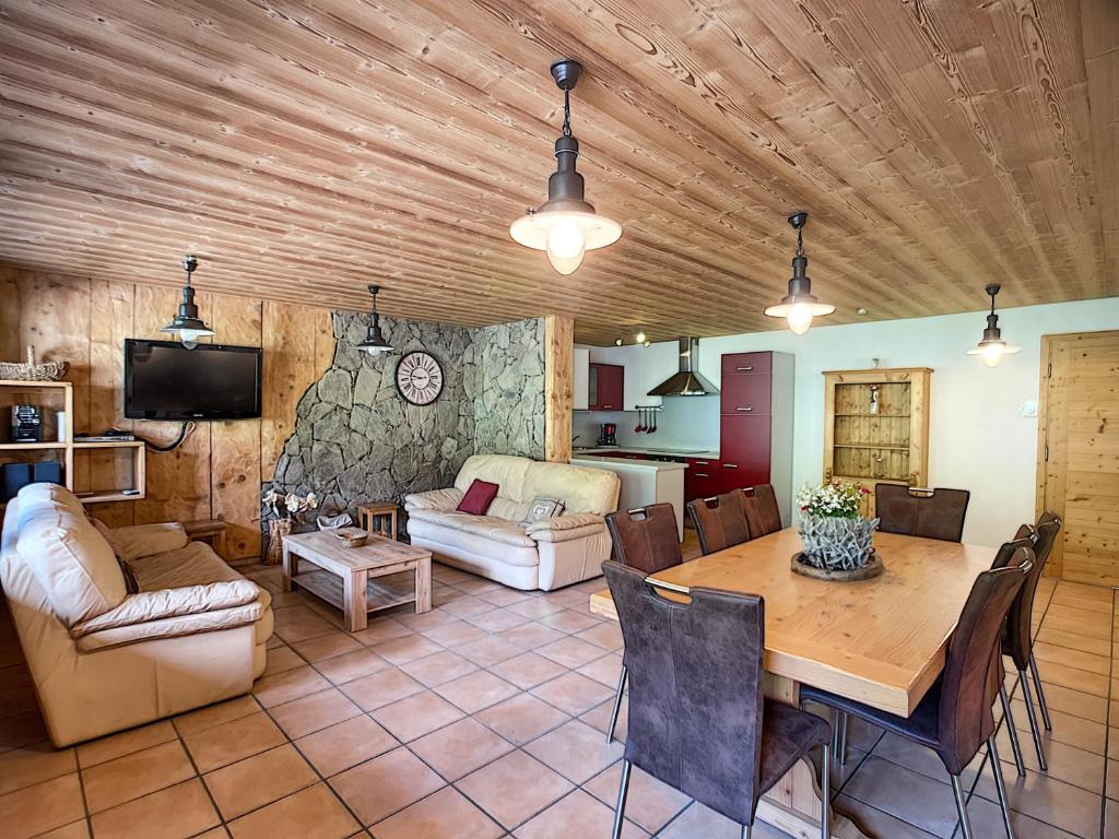 un salon avec un plafond en bois et une table dans l'établissement Rossin - appartement - 8 pers - ski-in-out, aux Gets