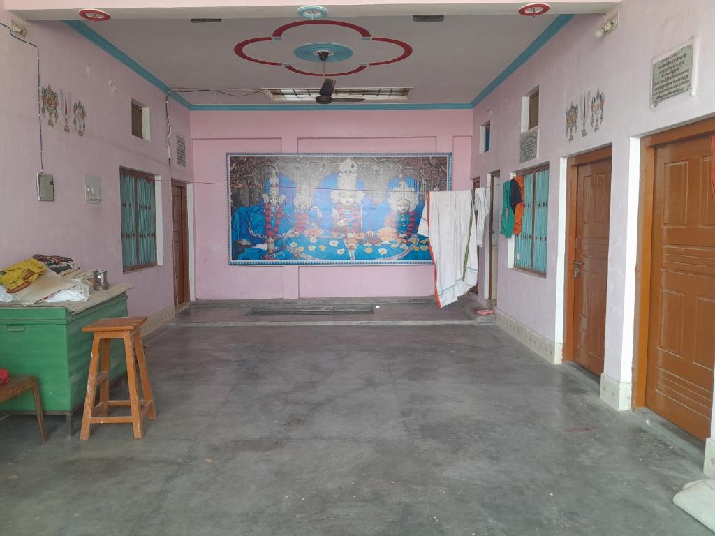 an empty room with a painting on the wall at Ram priya plaice 5 mint waking Ram mandir in Ayodhya