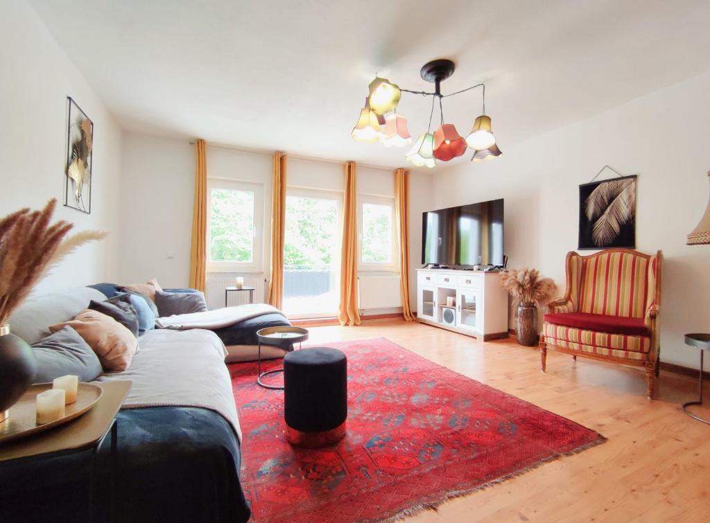 a living room with a couch and a red rug at Haus Mediterran - Gemütliches Ferienhaus 130 m² für max. 7 Personen mit Balkon und Garten am Bodensee in Radolfzell am Bodensee