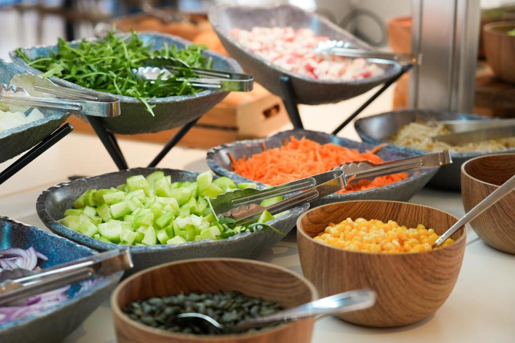a table topped with bowls of different types of vegetables at htop Amatista #htopBliss in Lloret de Mar