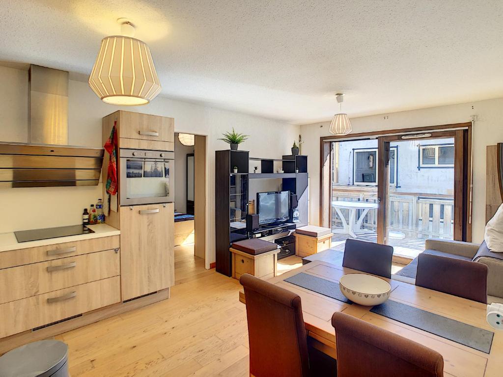 une cuisine et un salon avec une table et une salle à manger dans l'établissement Le Schuss - appartement - 4 pers - centre ville, aux Gets
