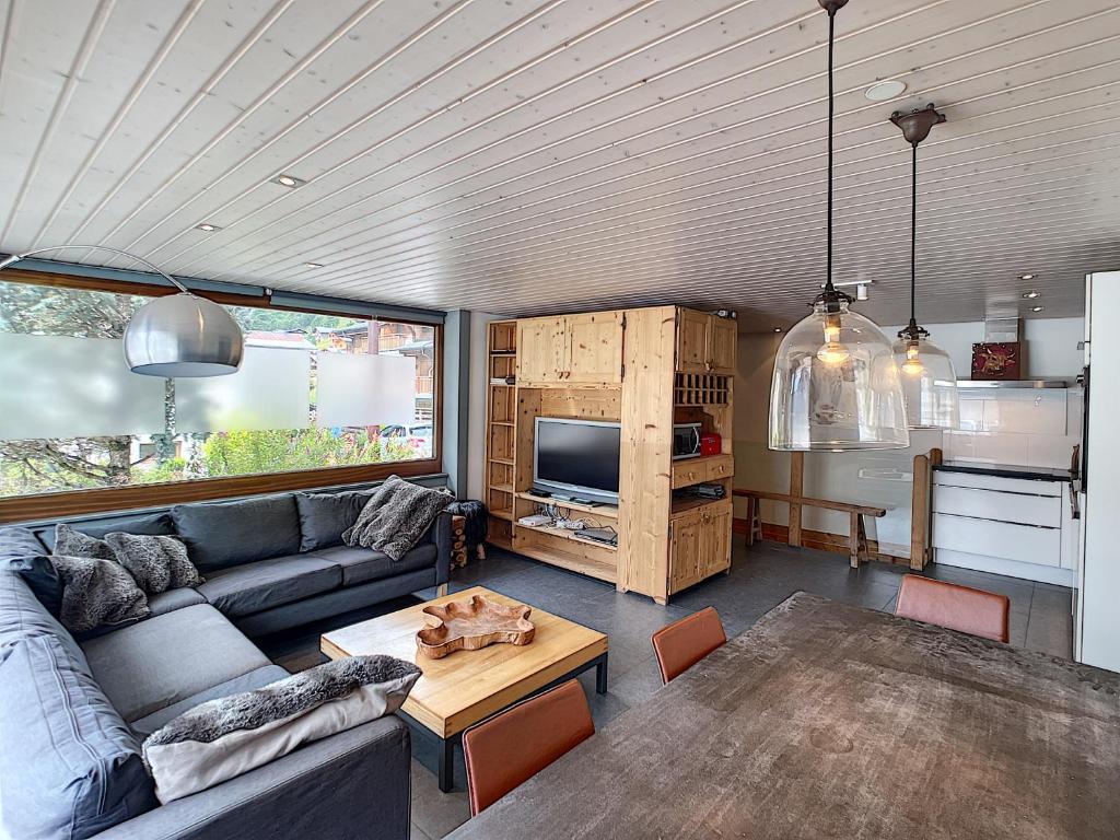 a living room with a couch and a table at Mont Caly - appartement - 8 pers - centre in Les Gets