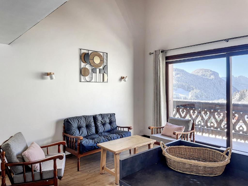 un salon avec un canapé, des chaises et une fenêtre dans l'établissement Cornuts 2 - appartement -5pers, aux Gets