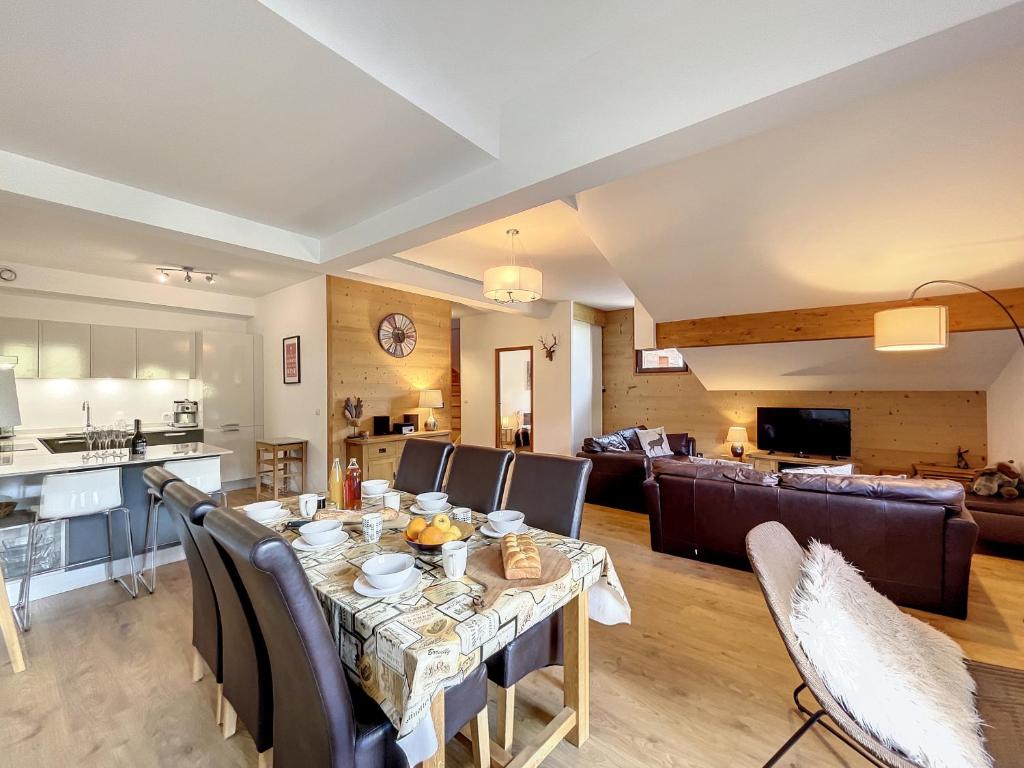une salle à manger et un salon avec une table et des chaises dans l'établissement Bois de Chene - appartement - 6pers- proche centre, aux Gets