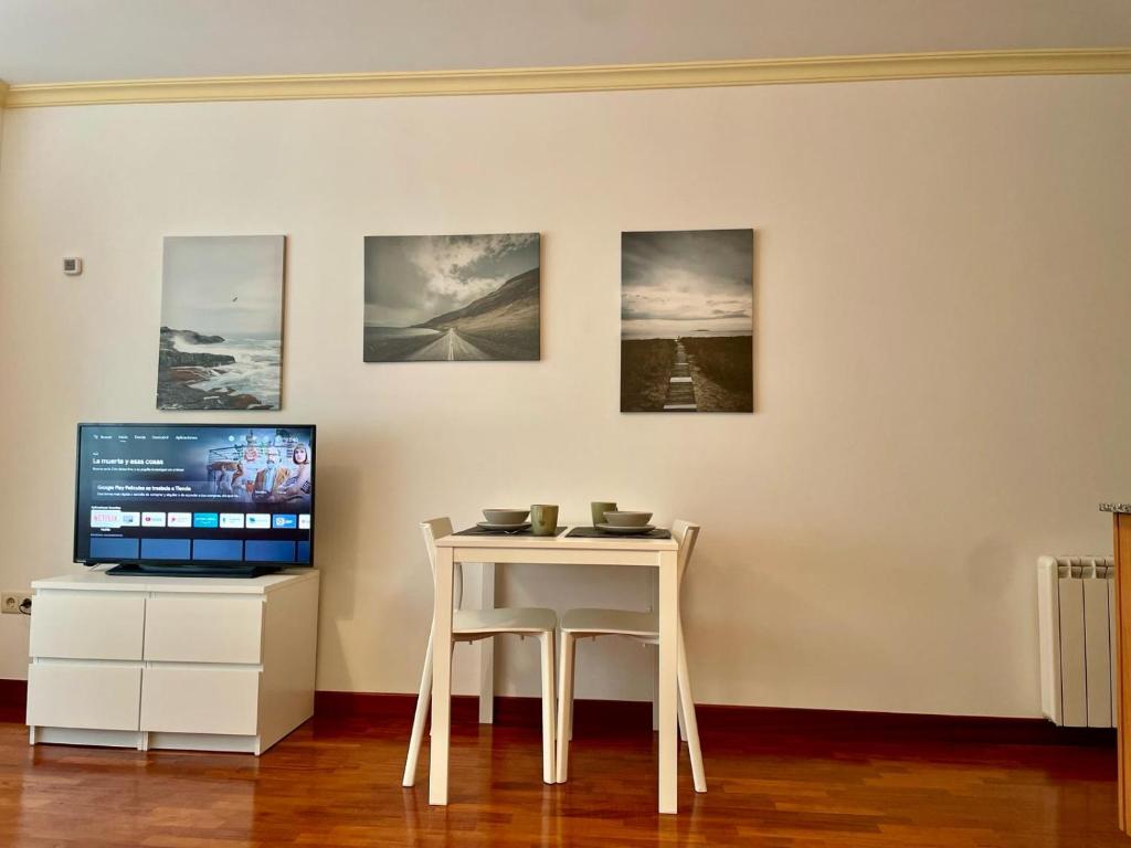 a white table with a television and a table with a chair at Cies Suitel López de Neira 28 - Love your Stay in Vigo