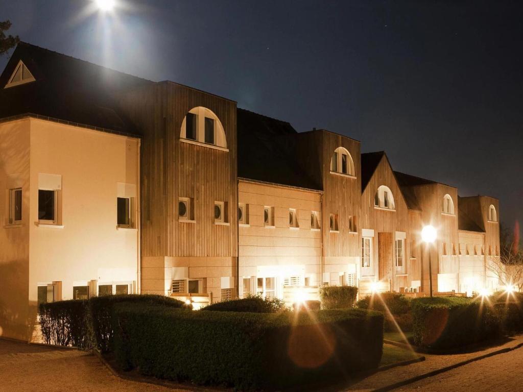 ein großes Gebäude in der Nacht mit eingeschaltetem Licht in der Unterkunft Holiday resort Golfe du Morbihan Larmor Baden acc for 4 pers in Larmor-Baden