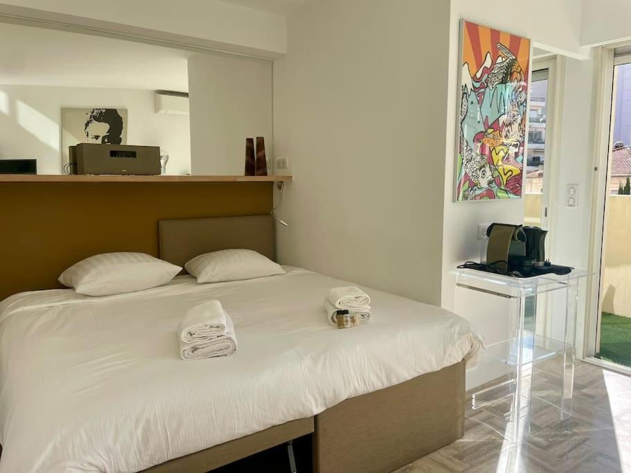 une chambre avec un lit avec deux serviettes dessus dans l'établissement L'Olivier - Croisette Martinez, Studio sur cour, plage 1 min, à Cannes