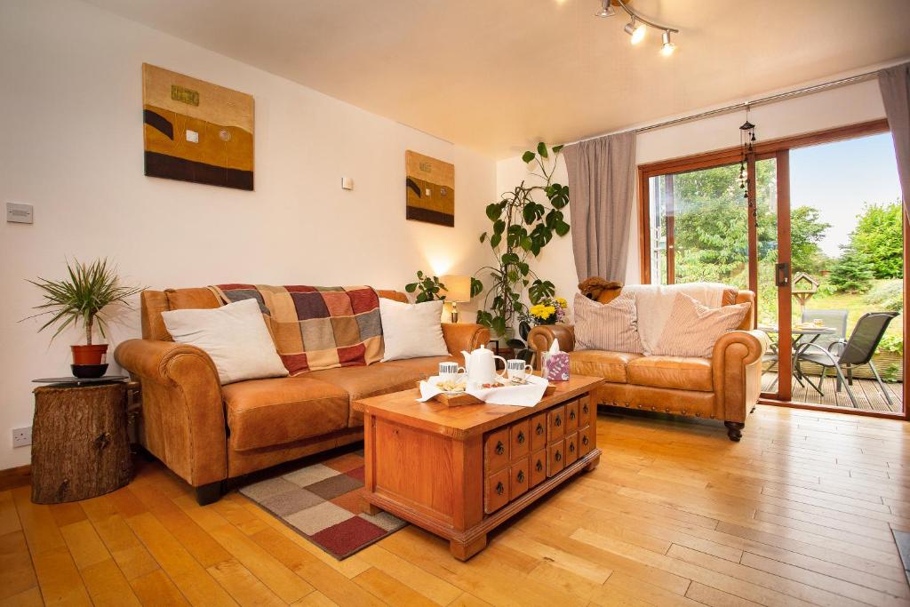 a living room with two couches and a coffee table at 5-Bed Highland Lodge - NC500 - Sleeps 10 in Alness