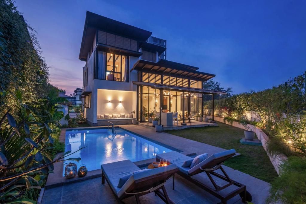 a house with a swimming pool in the backyard at LohonoStays Villa Siena D in Alibaug