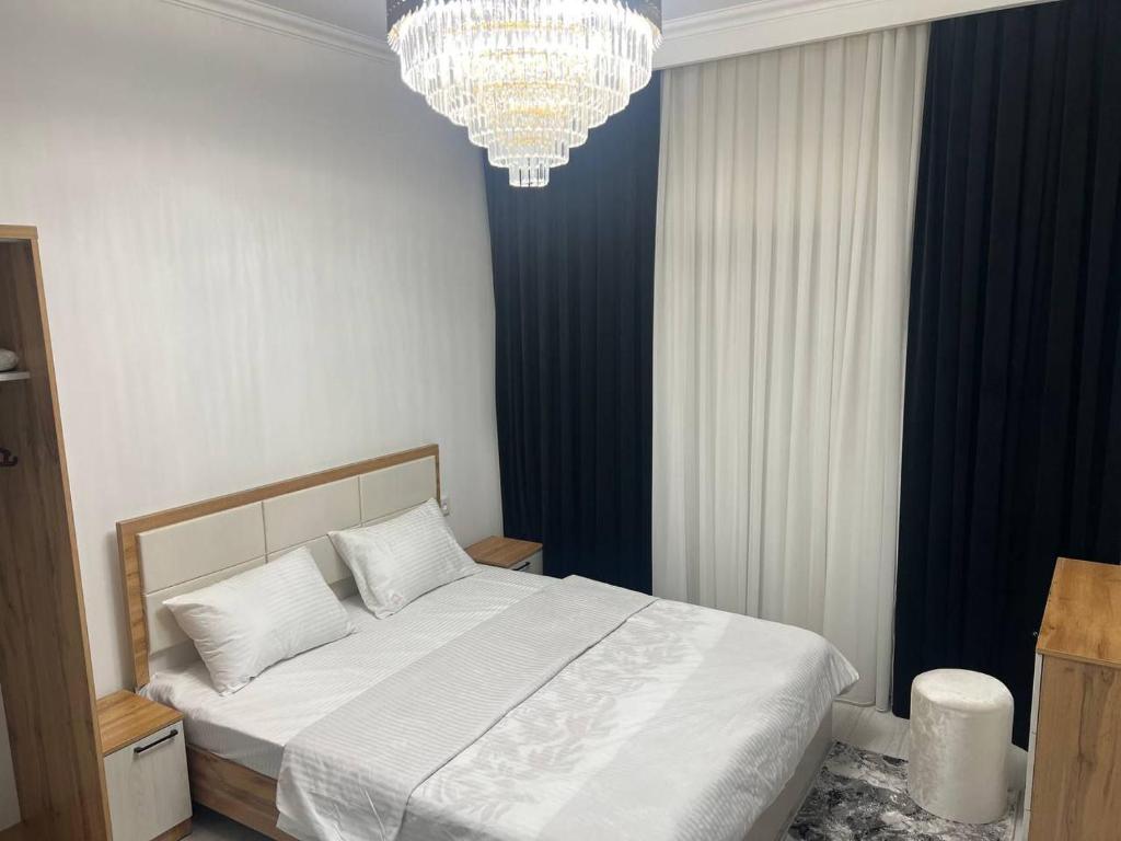 a bedroom with a bed and a chandelier at Lux Istanbul City in Yakkasaray