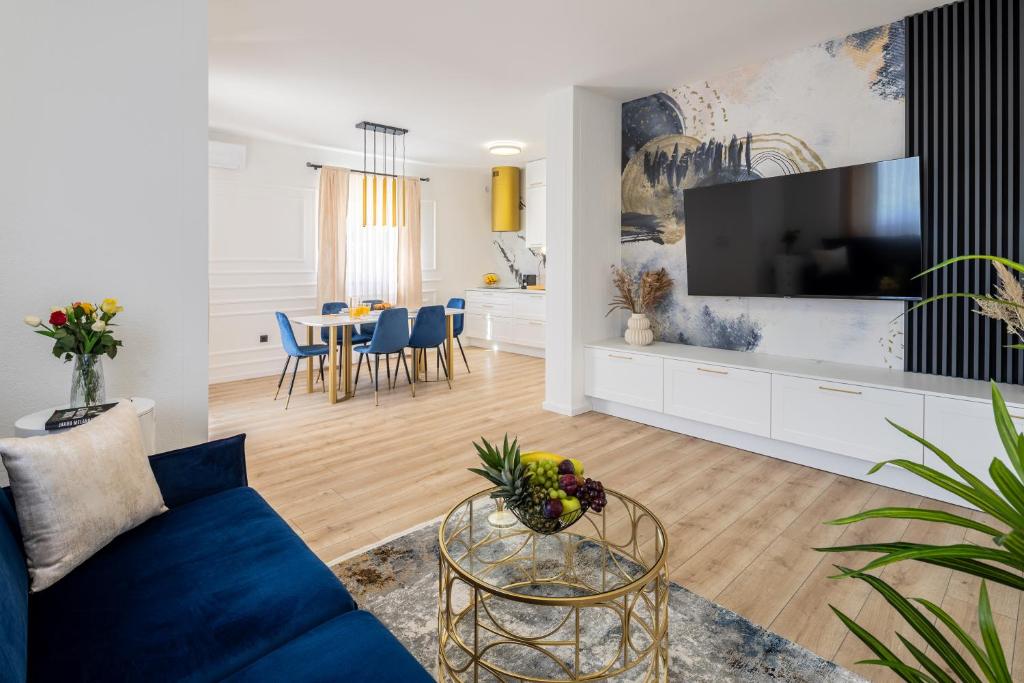 a living room with a blue couch and a tv at VIPo Seget Apartments in Trogir