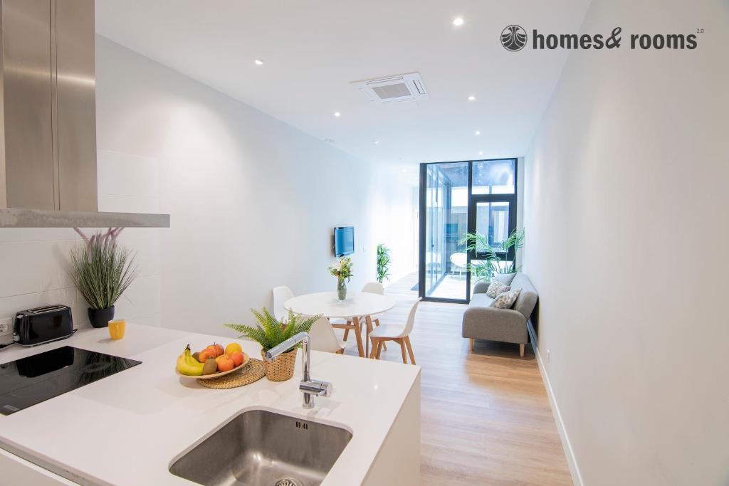 a white kitchen with a sink and a table at Enorme apartamento con 4 baños in Santiago de Compostela