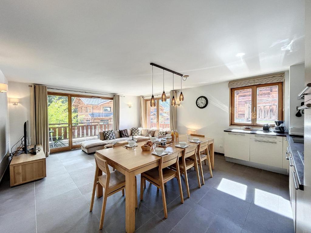 une cuisine et un salon avec une table et des chaises dans l'établissement Le K2 1- appartement- 6pers -proche pistes, aux Gets