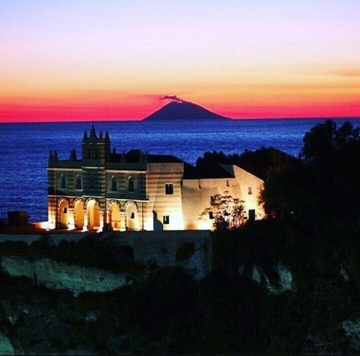 a house sitting on top of the ocean at sunset at BLOOM in Tropea