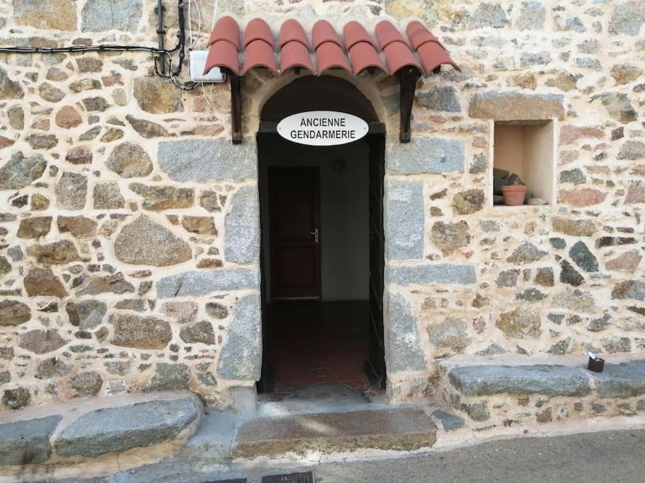 Drzwi do kamiennego budynku z napisem w obiekcie Ravissant appartement au cœur de Piana w mieście Piana