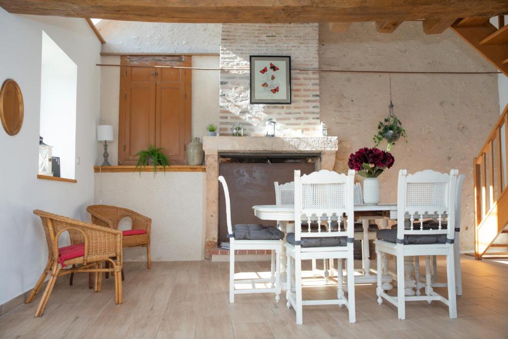 une salle à manger avec une table et des chaises blanches dans l&#39;établissement La petite Touche, à Couddes